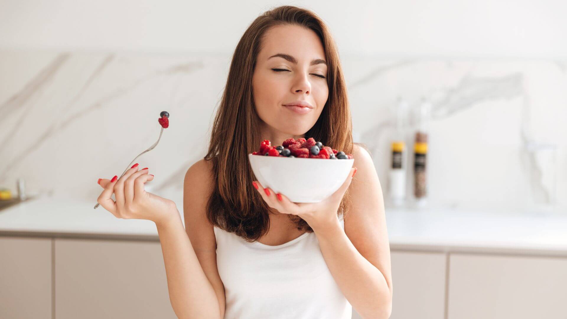 Woman eating low potassium berries to illustrate content of our low potassium food list