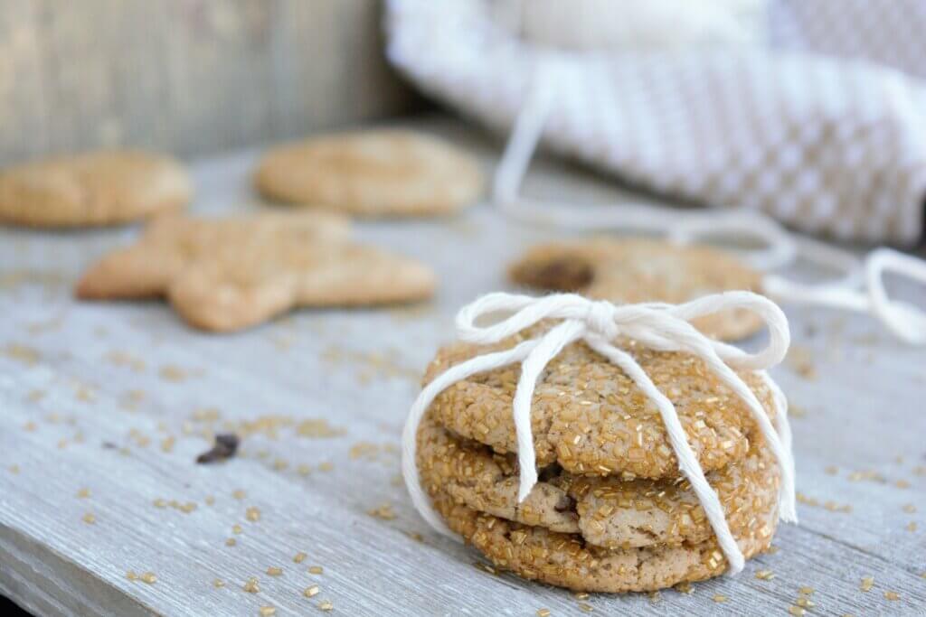 Stack of three kidney friendly ginger cookies tied with white yarn on a wooden cutting board
