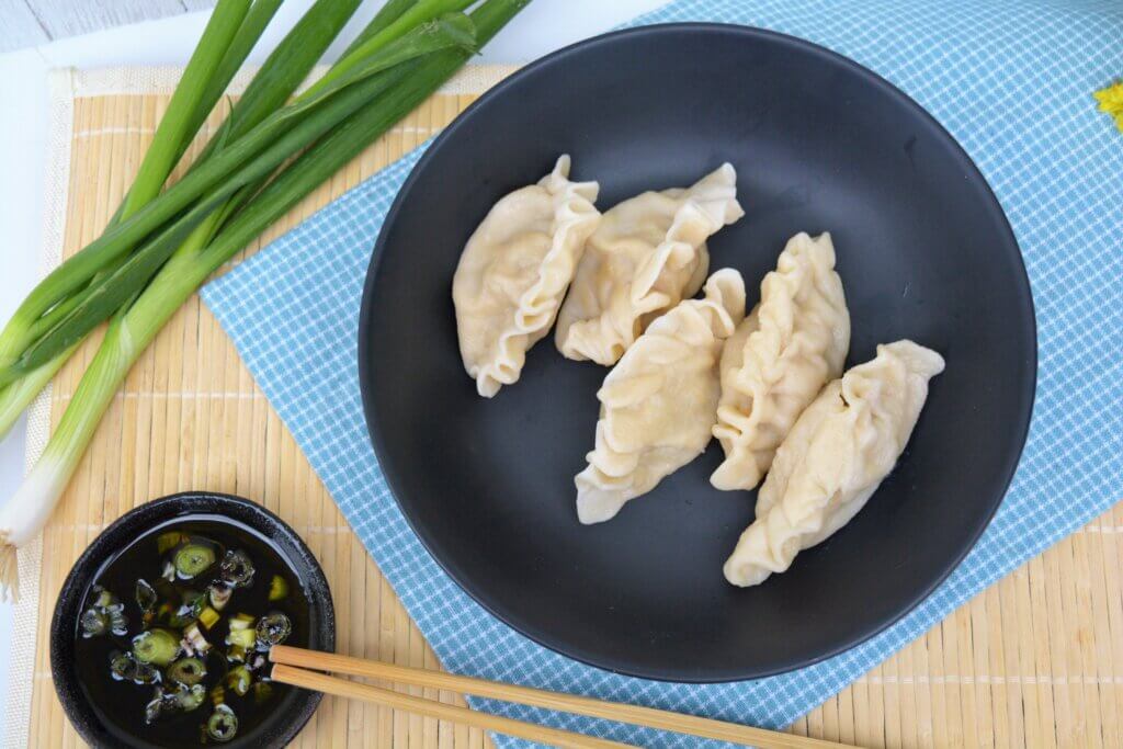 low sodium dumplings for renal diet on black plate with low sodium dipping sauce