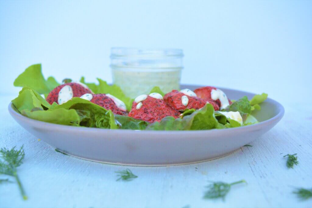 low potassium strawberrie and greens salad on plate with low phosphorus creamy dressing for kidney diet
