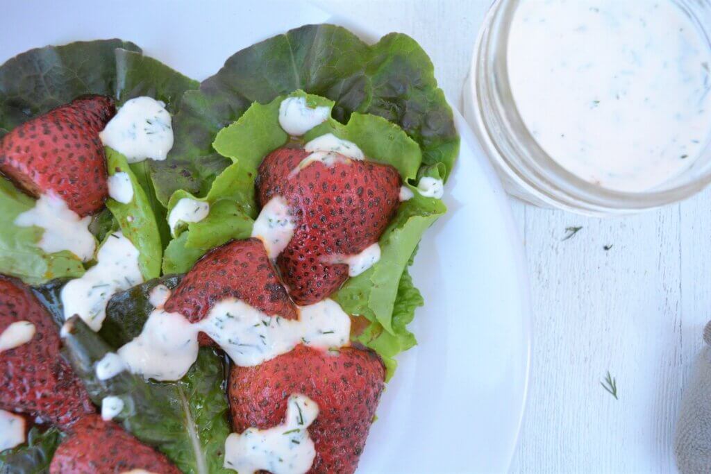 low potassium strawberrie and greens salad on plate with low phosphorus creamy dressing for kidney diet