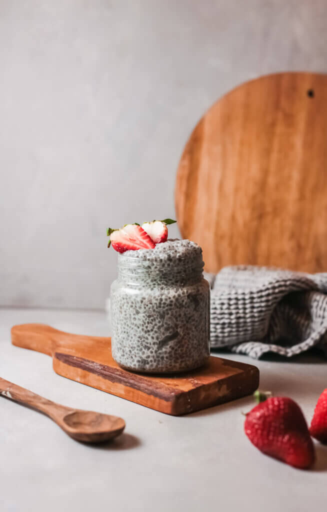 Chia pudding with spoon on wooden board