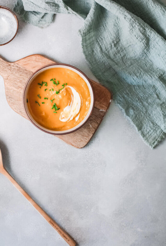 Curried carrot soup with towel and board and spoon-kidney friendly