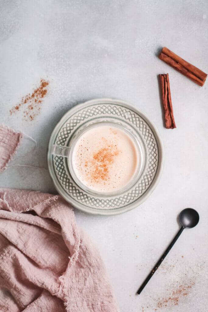 Top view molasses milk with cinnamon sticks, towel and spoon-kidney friendly