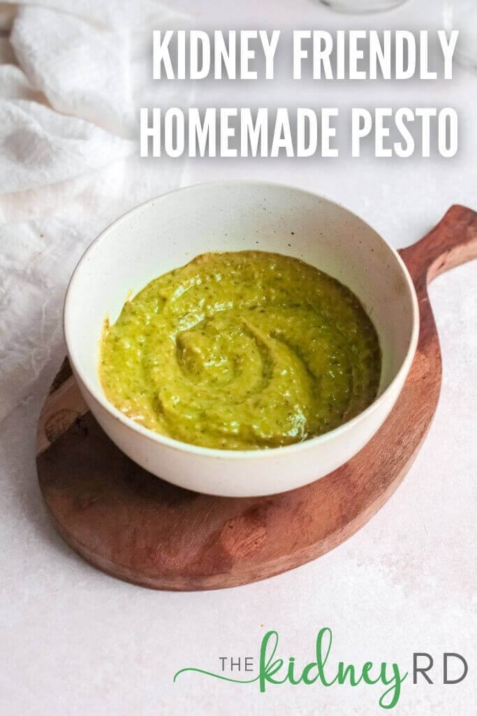 Side view of low sodium homemade pesto in a white bowl on a wooden 