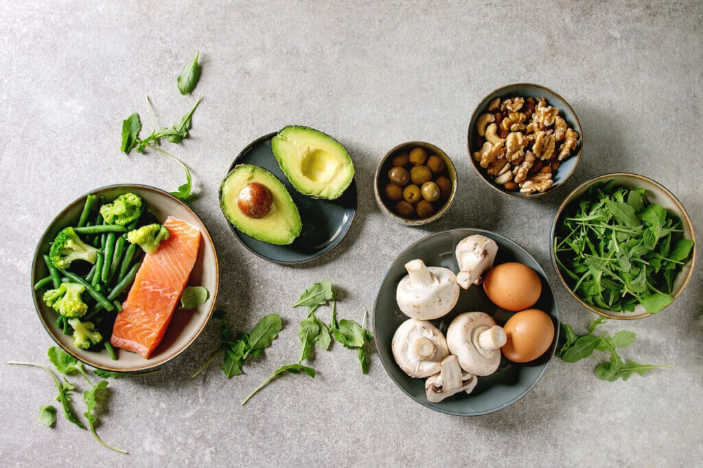 Overhead view of ketogenic diet foods in grey bowls on a grey table