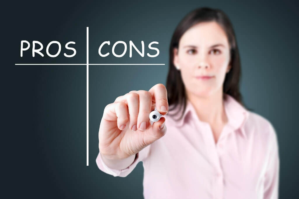 Woman writing pros and cons list with a black marker