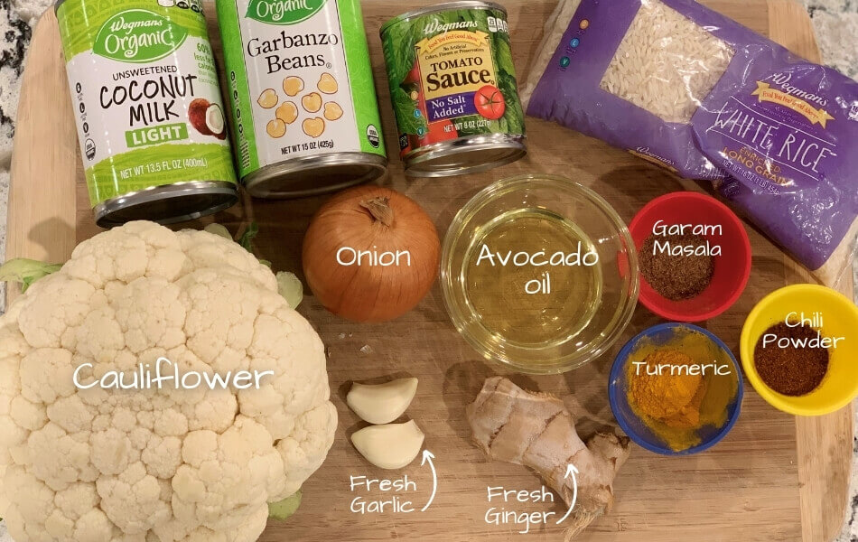 Labeled Ingredients laid out for vegan tikka masala on a bamboo cutting board