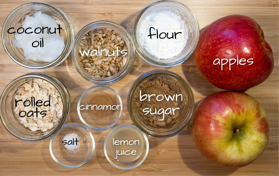 View of all ingredients in this low potassium dessert including coconut oil, walnuts, flour, apples, rolled oats, cinnamon, brown sugar, salt, and lemon juice.