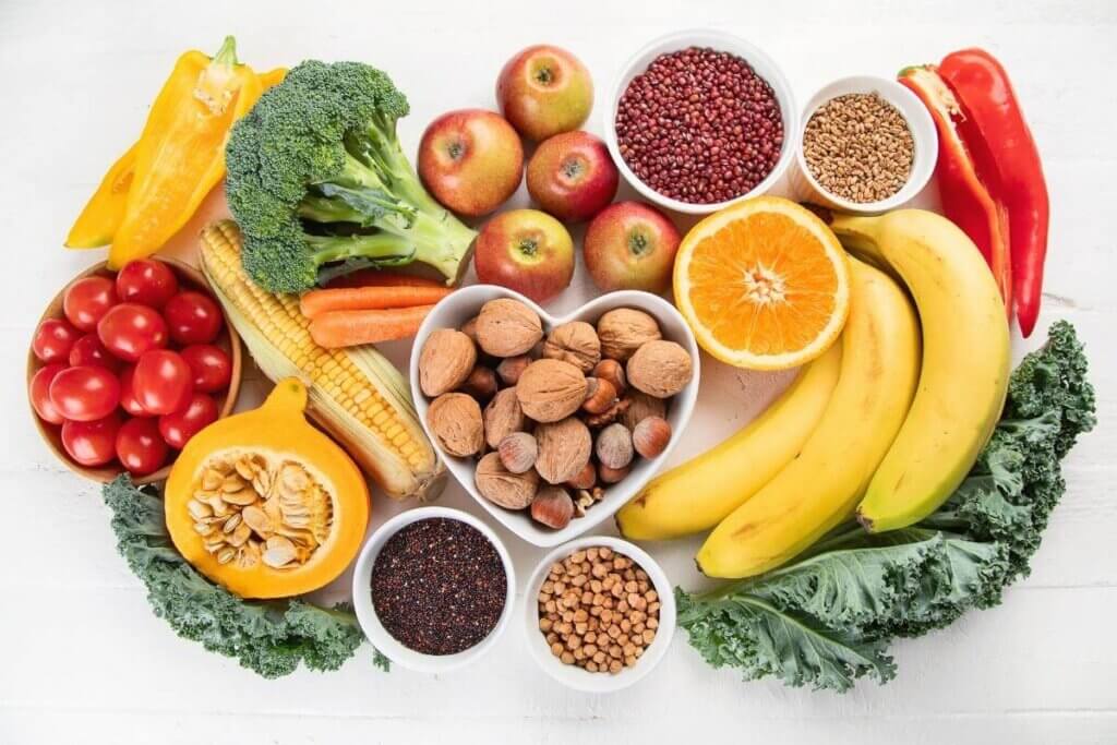 Overhead view of different high fiber plant foods like fruit, vegetables, whole, grains, nuts