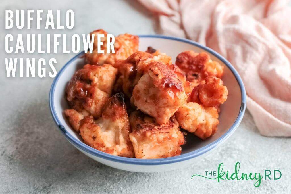 Overhead view of buffalo cauliflower wings in a white bowl with pink tea towel next to bowl