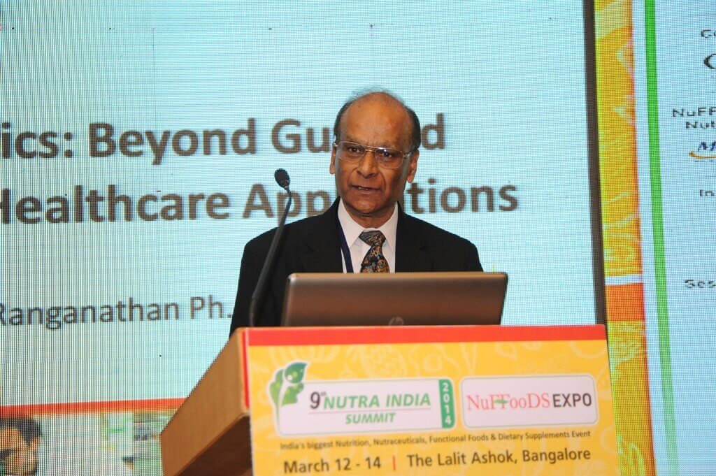 Dr. Ranganathan standing at a podium presenting at a conference.