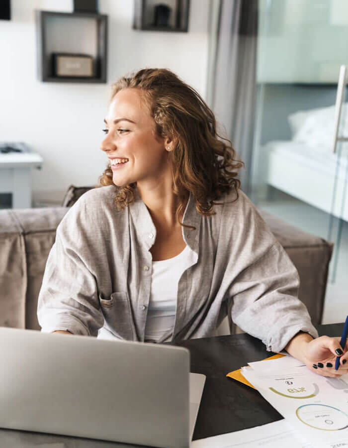 white woman reviewing reports at her laptop