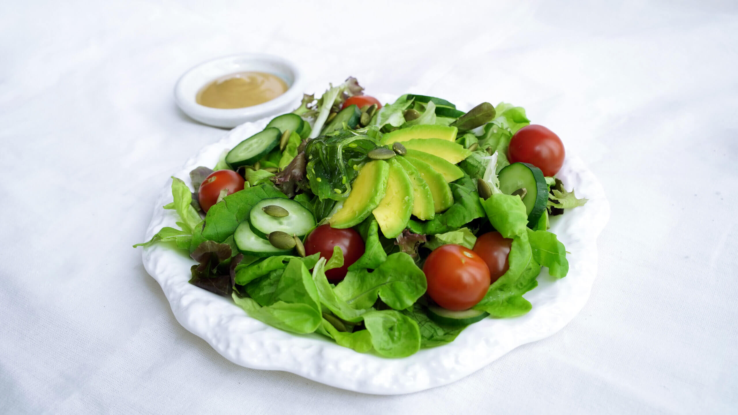 Japanese inspired Sesame Salad1 with sesame dressing in a small bowl on the side