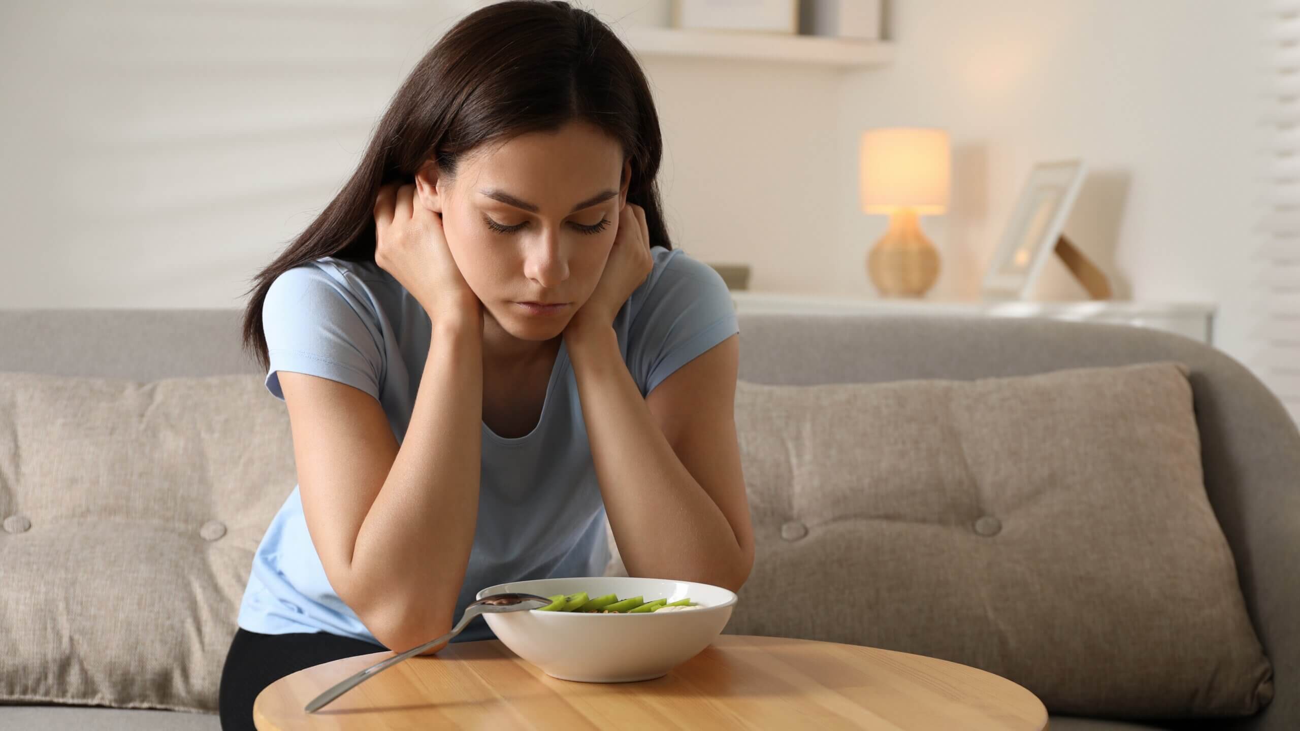 Female staring at food in fear of health