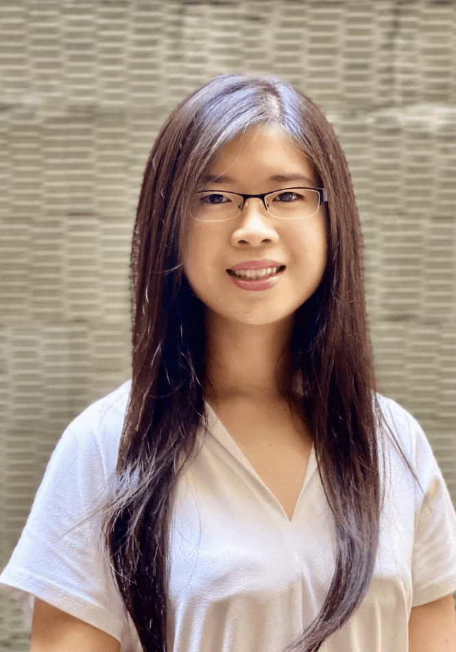 Asian woman with long dark hair and wire rimmed glasses in a white v-neck t shirt