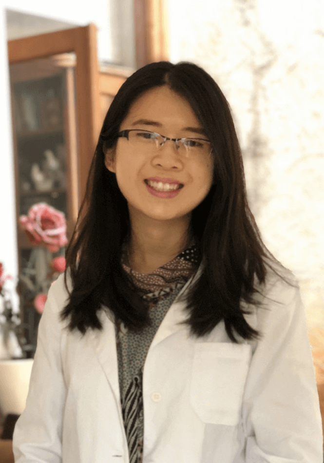 Asian woman with should length black hair and wire rimmed glasses in a white lab coat
