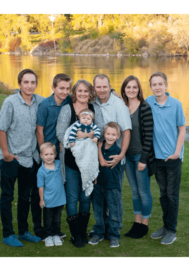 large family posed together by lake